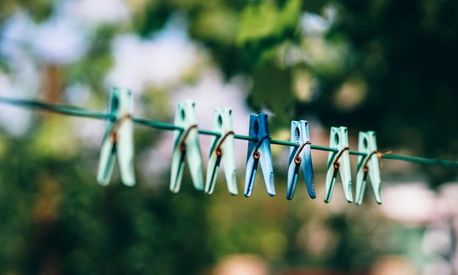 A clothes line with blue pegs hanging on it